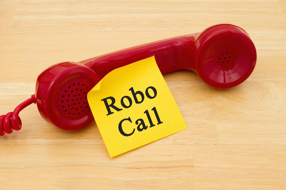 Getting a call from a Robocall, Retro red phone handset with a yellow sticky note and text Robocall