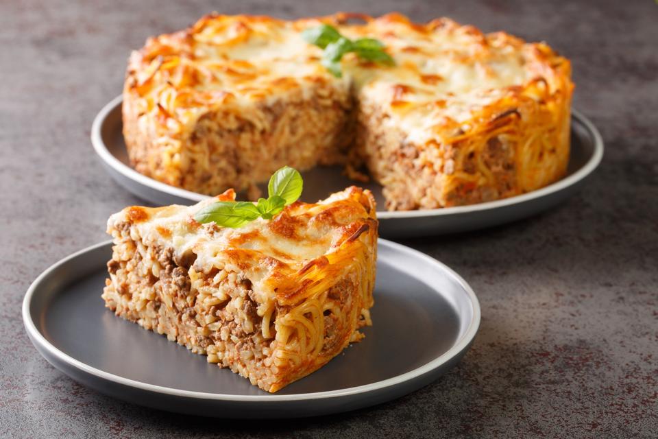 Cheesy Baked Spaghetti Pie with Ground beef, spicy and tomato sauce closeup in the plate. Horizontal