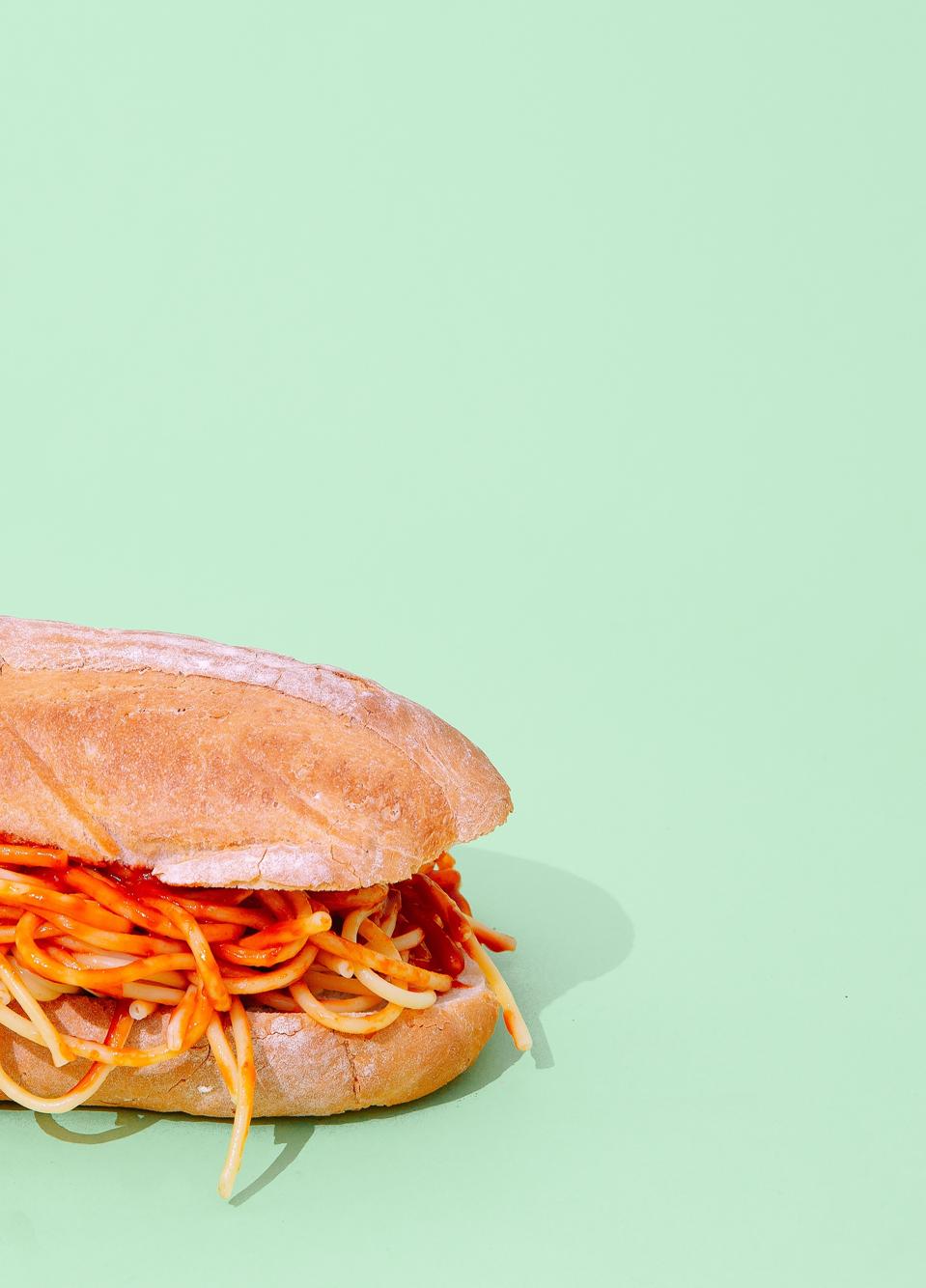 Creative Pasta sandwich on green background. Minimalism. Junk food art concept.