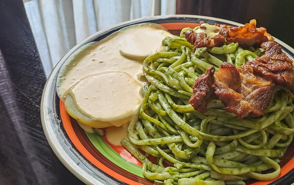Spaghetti Pesto peruvian way with fried meat and potato with huancaina sauce. Tallarines verdes con papa a la huancaina.