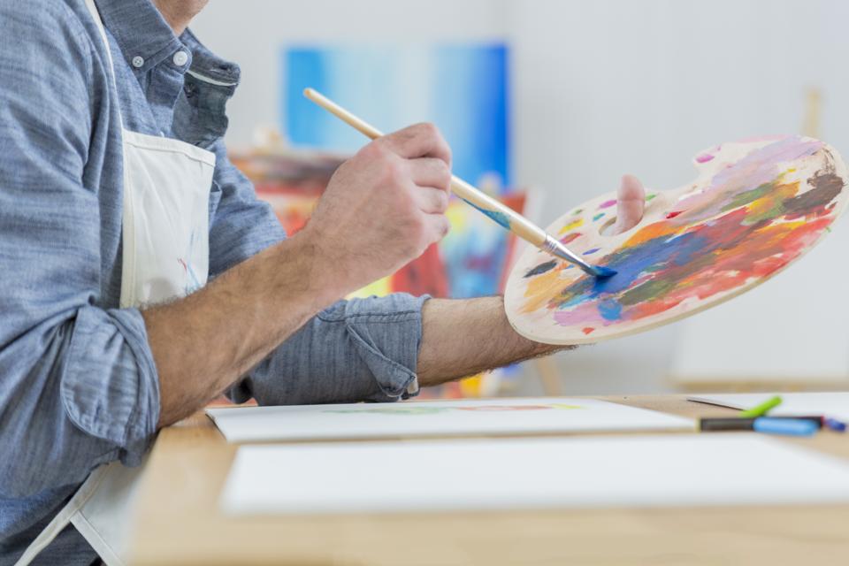 Artist blends paint on an artist's palette