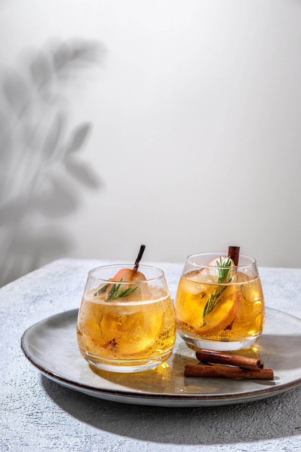Fresh cocktail with pear, ice and herbs on the  table. Refreshing drink on a hot summer day. Ice tea. Pear sangria or punch in a glass