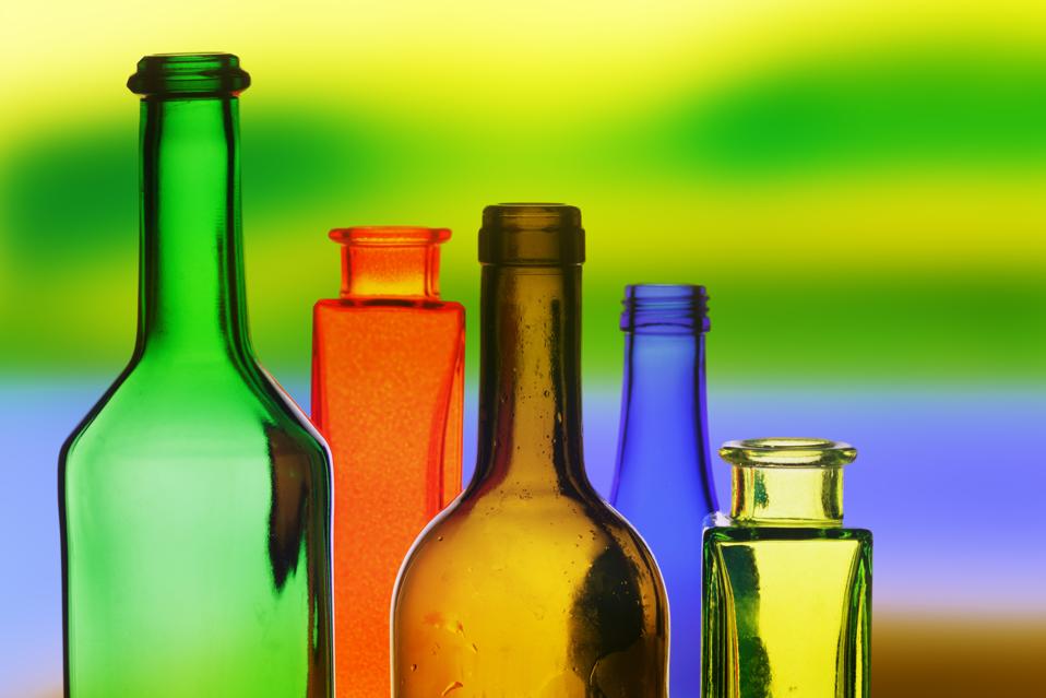 Colored glass bottles on a colorful background.