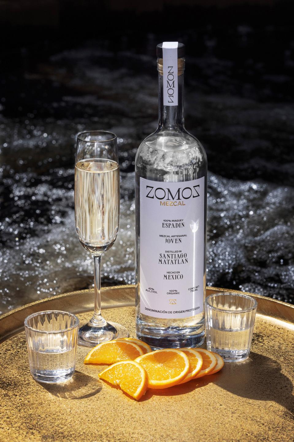 zomoz mezcal with glass of Champagne and orange slices