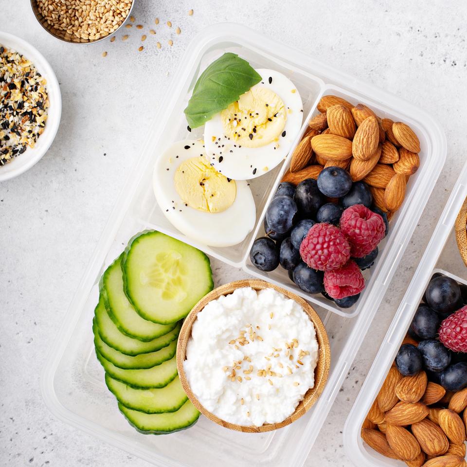 Snack box with high-protein food, cottage cheese, berries, cucumbers, nuts and eggs