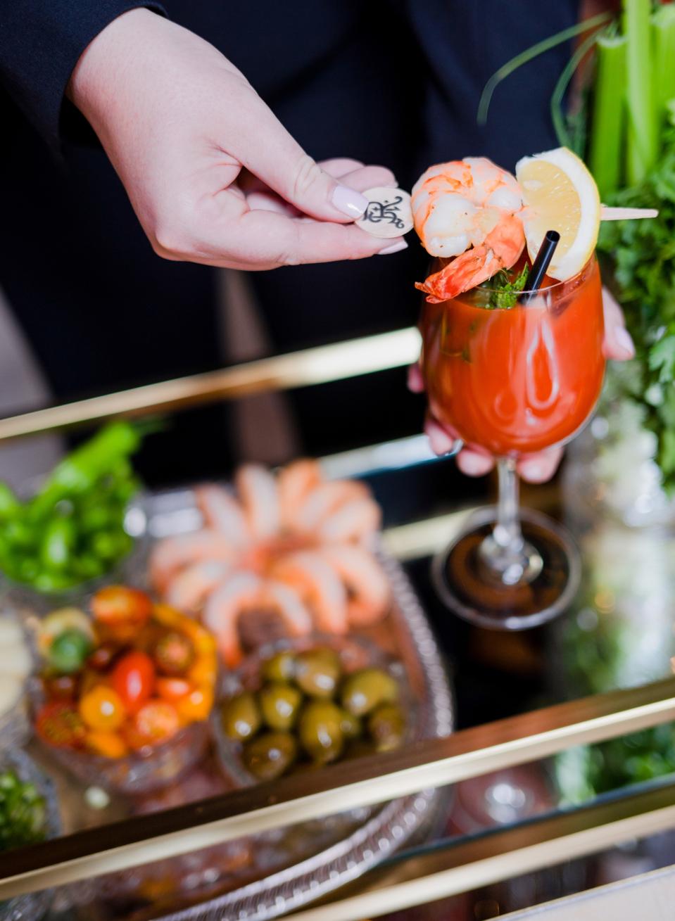 a bloody mary cocktail on a cart with garnishes