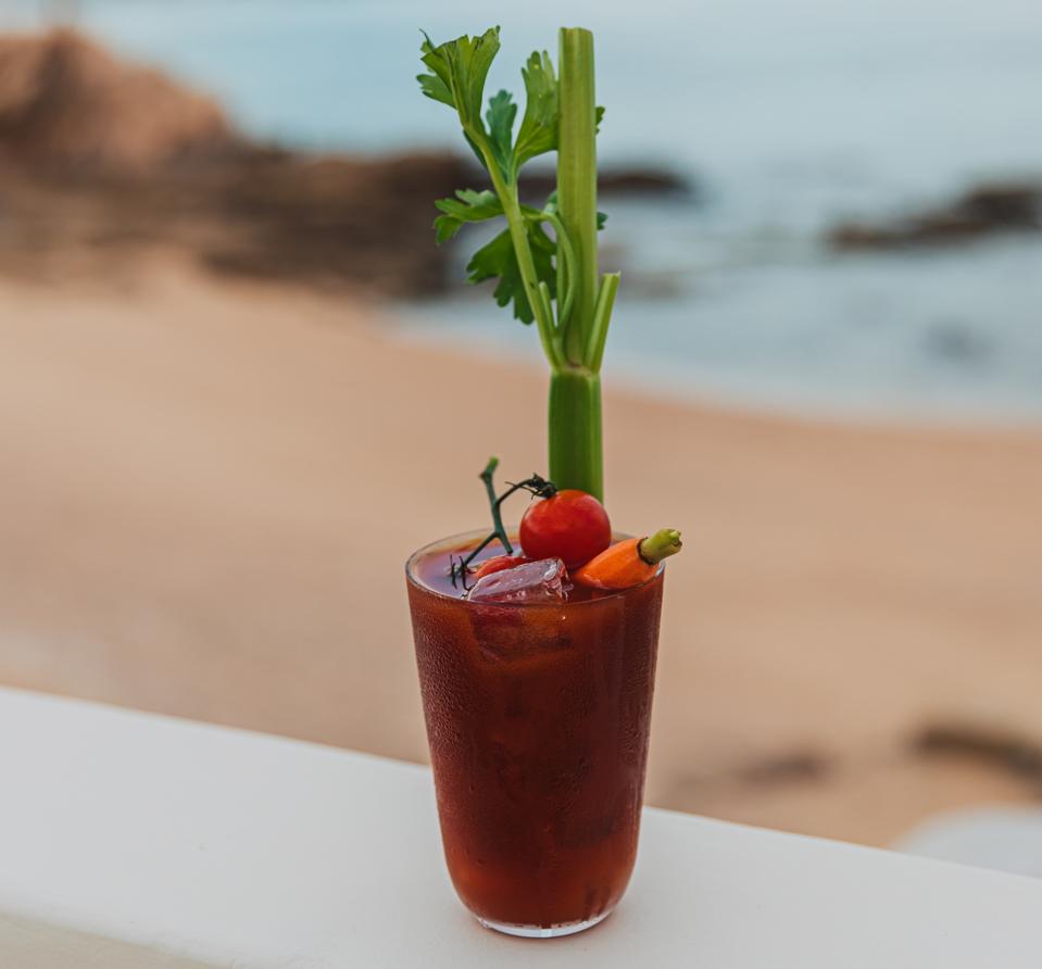 A garnished bloody mary on a seaside table