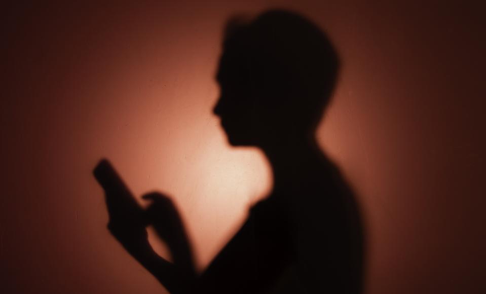 Phone user, red background.