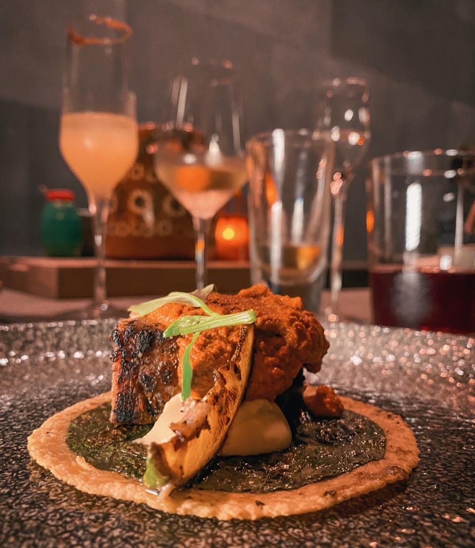 a fancy taco with a variety of drinks in the background