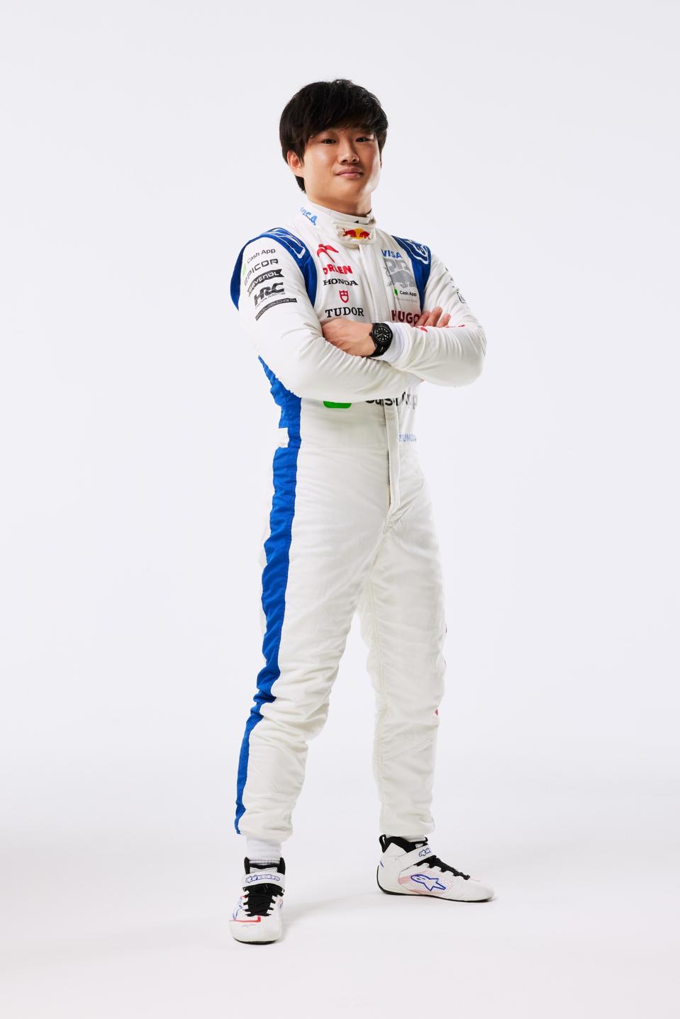 Yuki Tsunoda wearing the new V-CARB uniform at the reveal, with the Tudor shield