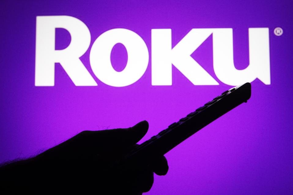In this photo illustration a Roku logo is seen on a screen...