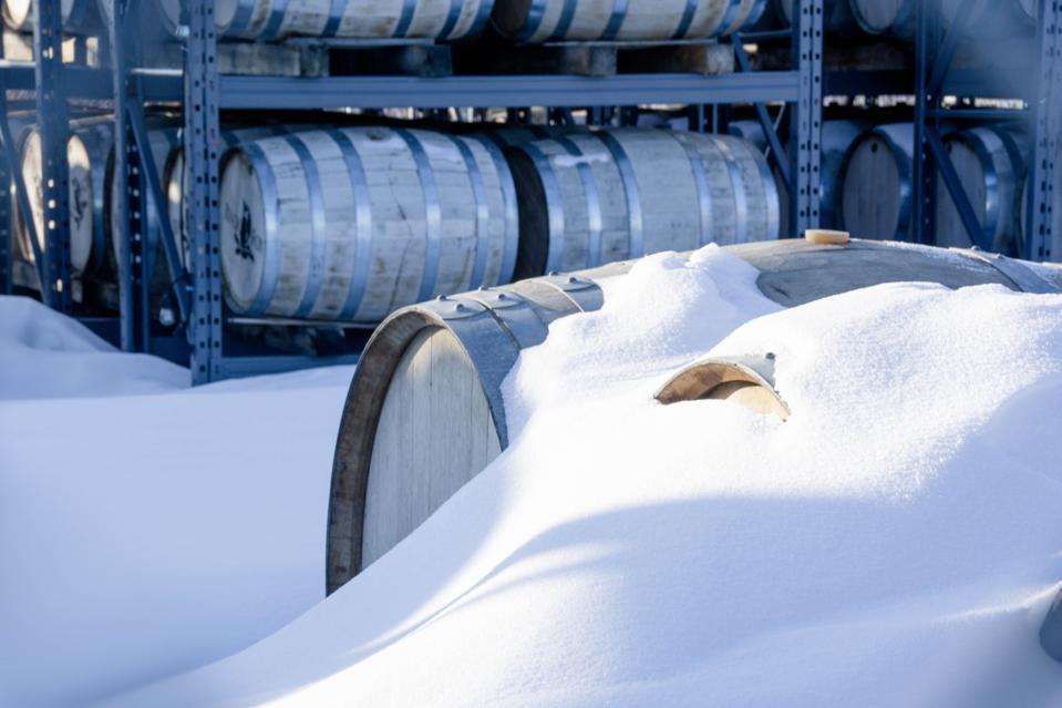 Barrels of whiskey aging in the snow at Black Fox Farm & Distillery.
