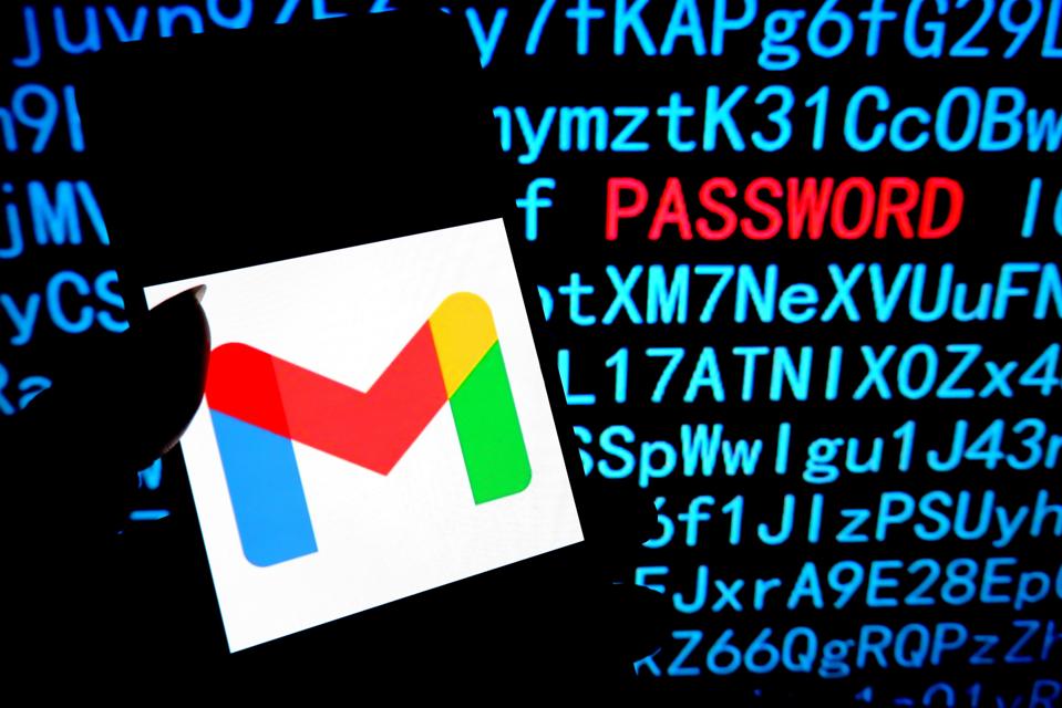 Gmail logo on a smartphone, with computer code seen behind and 'password' highlighted in red.