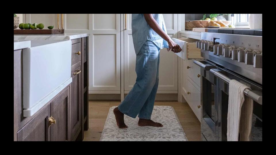 A woman standing on an anti-fatigue mat in the kitchen.