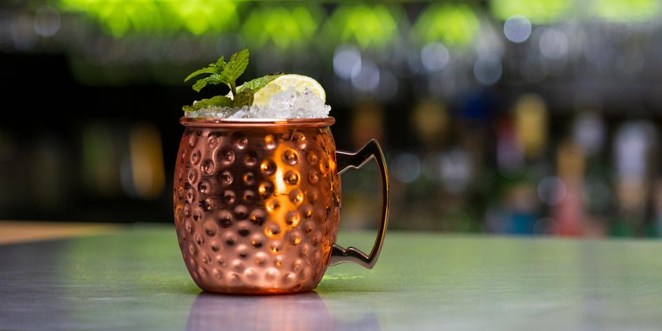 Moscow mule drink with ice cubes, lemon slice and mint leaves
