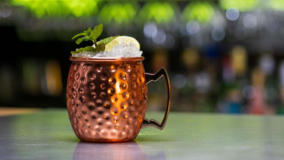Moscow mule drink with ice cubes, lemon slice and mint leaves