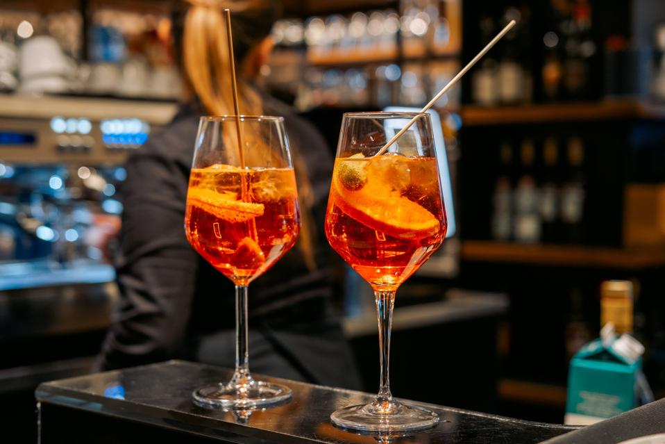 Traditional Italian cocktail Spritz with ice and olives in Italian bar, an aperitif in Rome, Milan Venice Florence