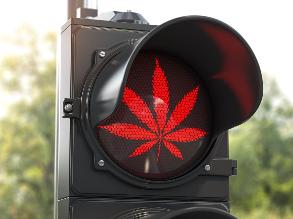 Cannabis leaf on red traffic light. 