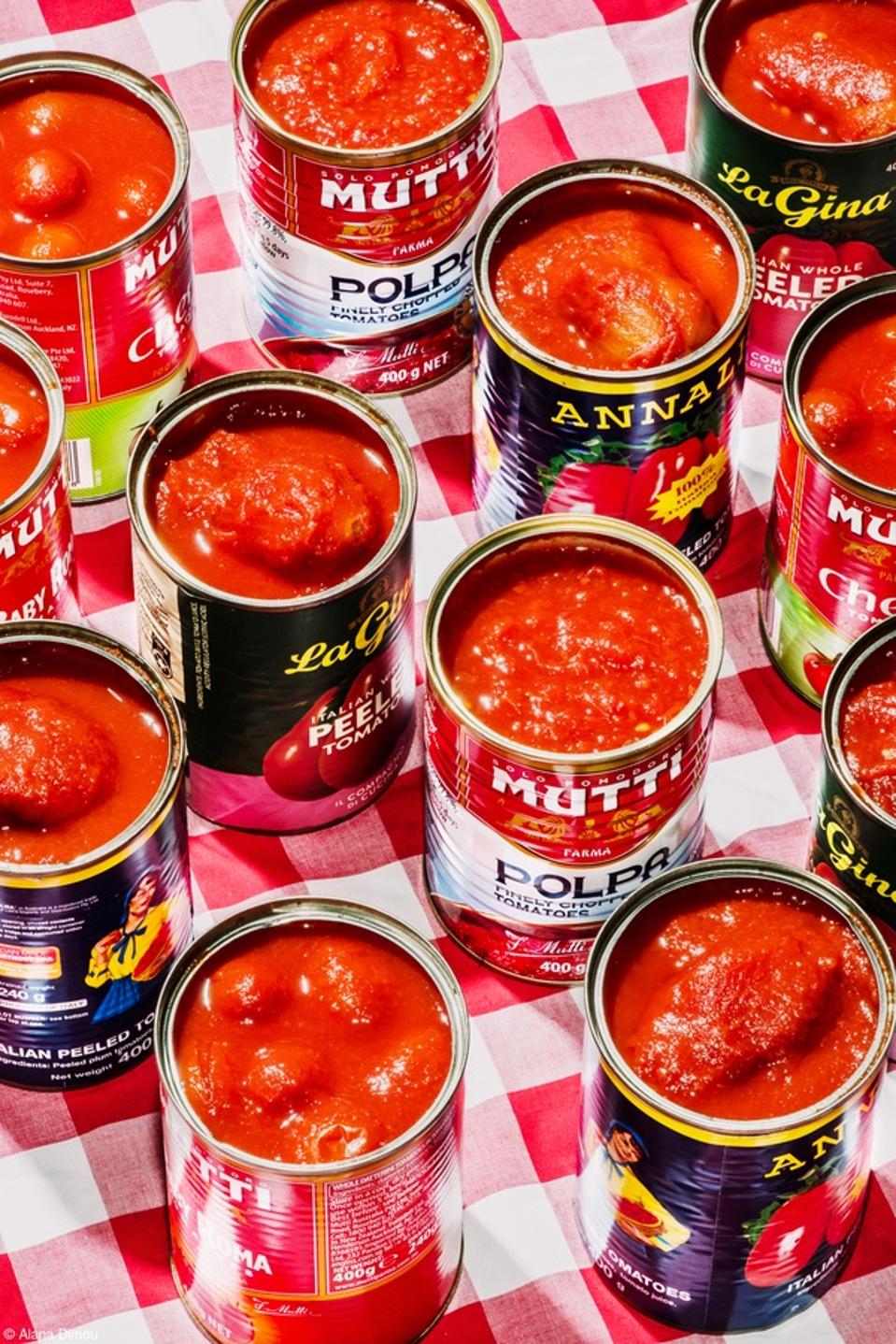 Tomato Cans from different brans opened on a checkered table.