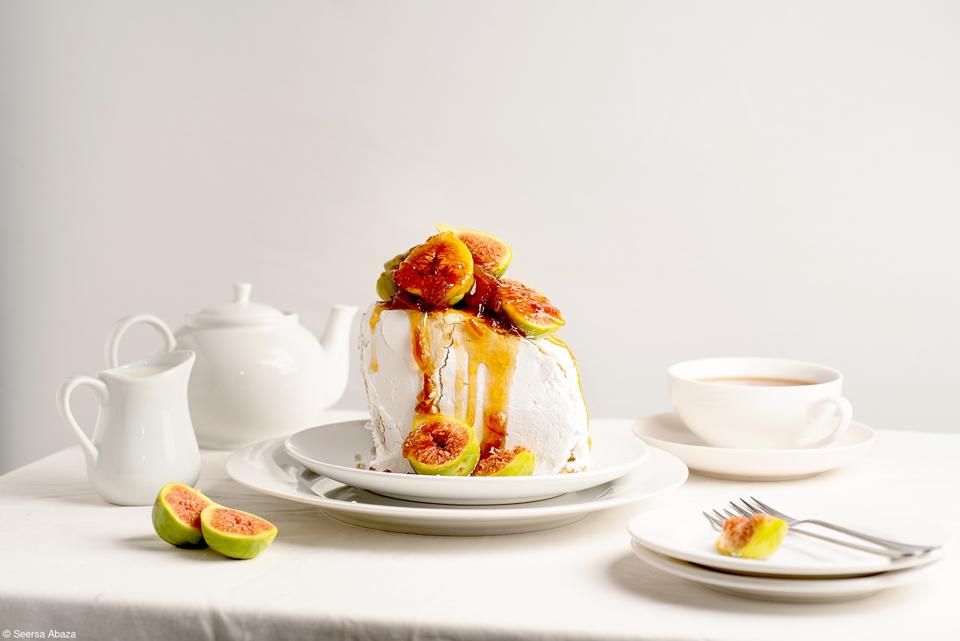 A white cake topped with fresh figs and drizzled with syrup,