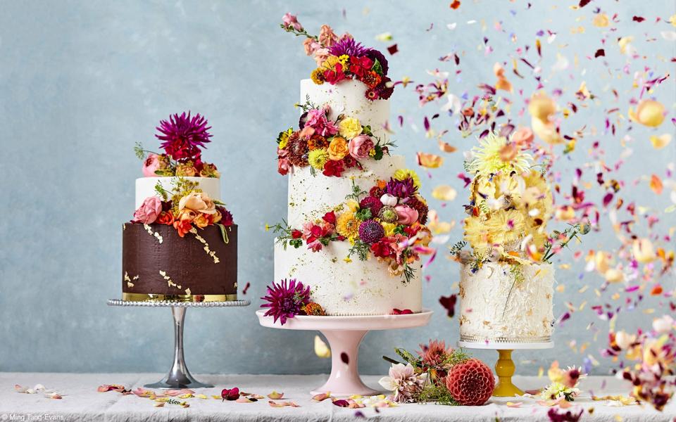 Three cakes covered in flowers petals.