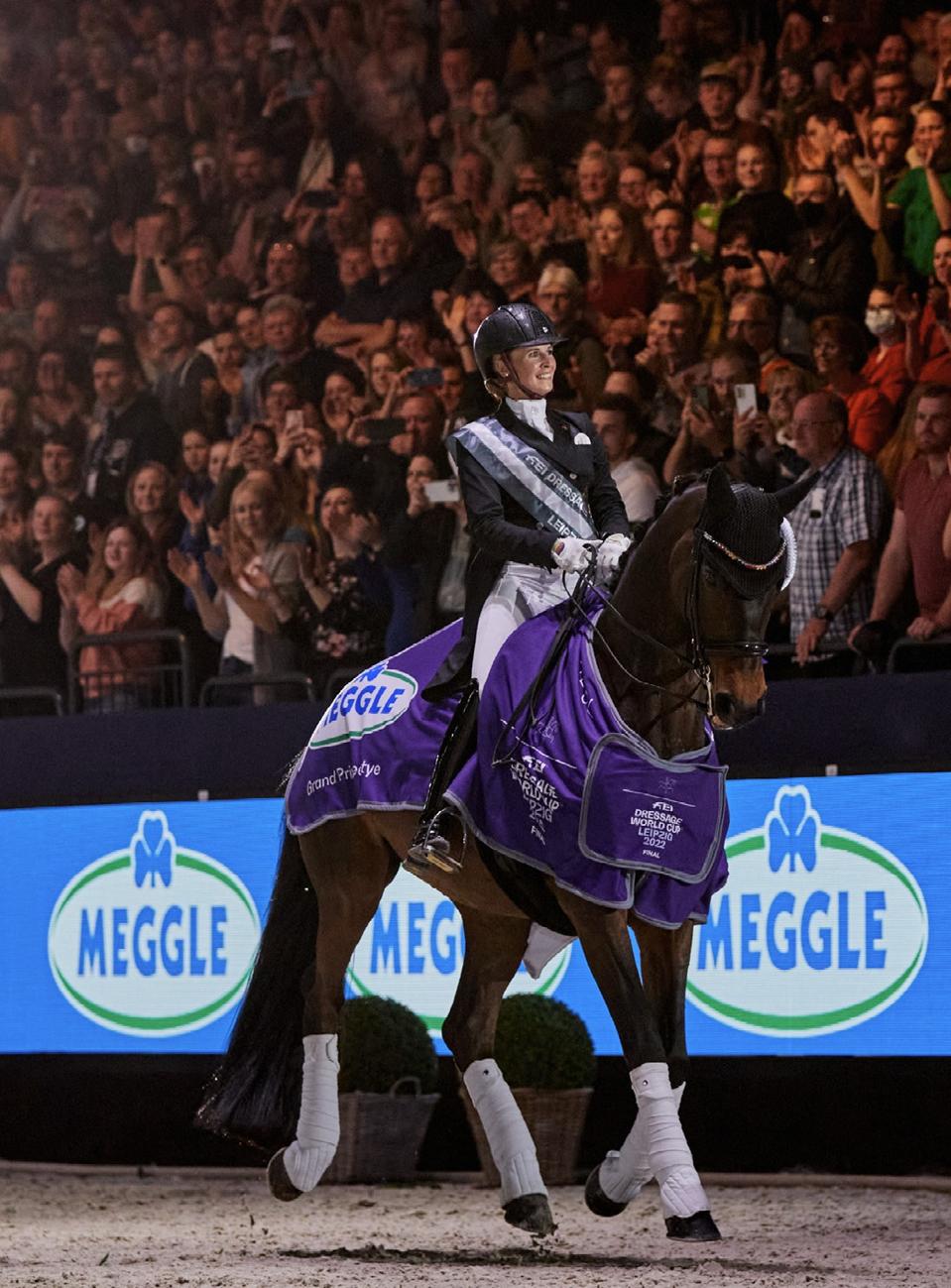 Jessica von Bredow-Werndl rides a horse in a dirt arena.