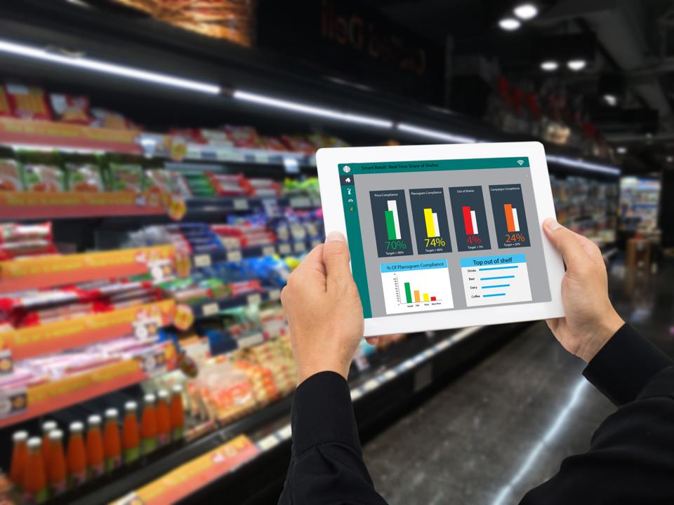 iot smart retail in the futuristic concept, the retailer hold the tablet and use augmented reality technology monitor data of out of shelve, price, planogram, campaign of compliance in the real time