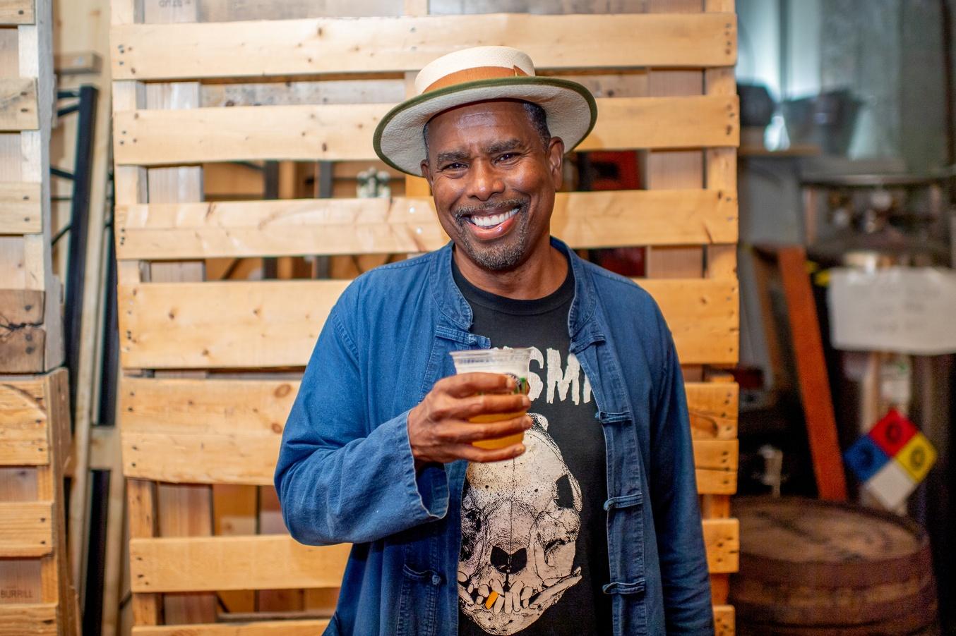 Brooklyn Brewery's Brewmanster, Garrett Oliver, smiles as he drinks a beer.