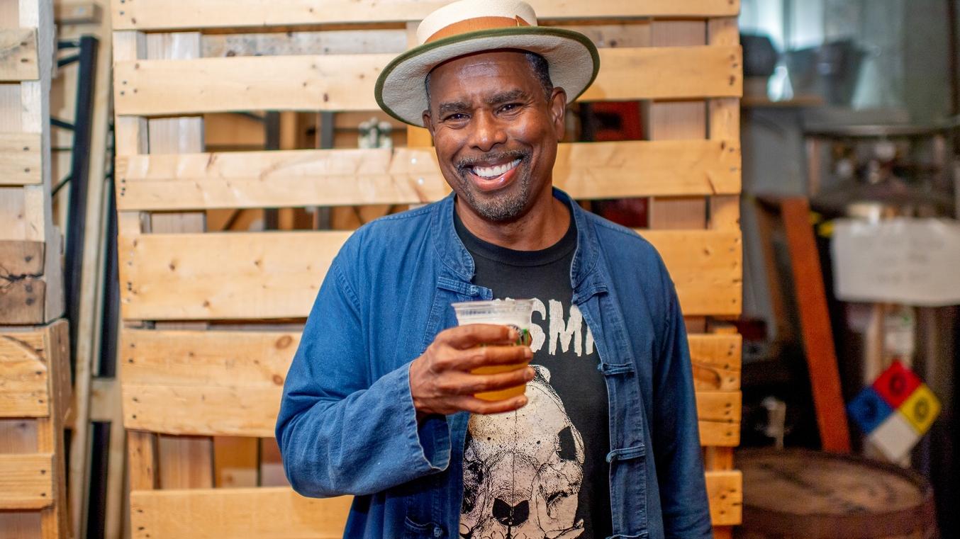 Brooklyn Brewery's Brewmanster, Garrett Oliver, smiles as he drinks a beer.