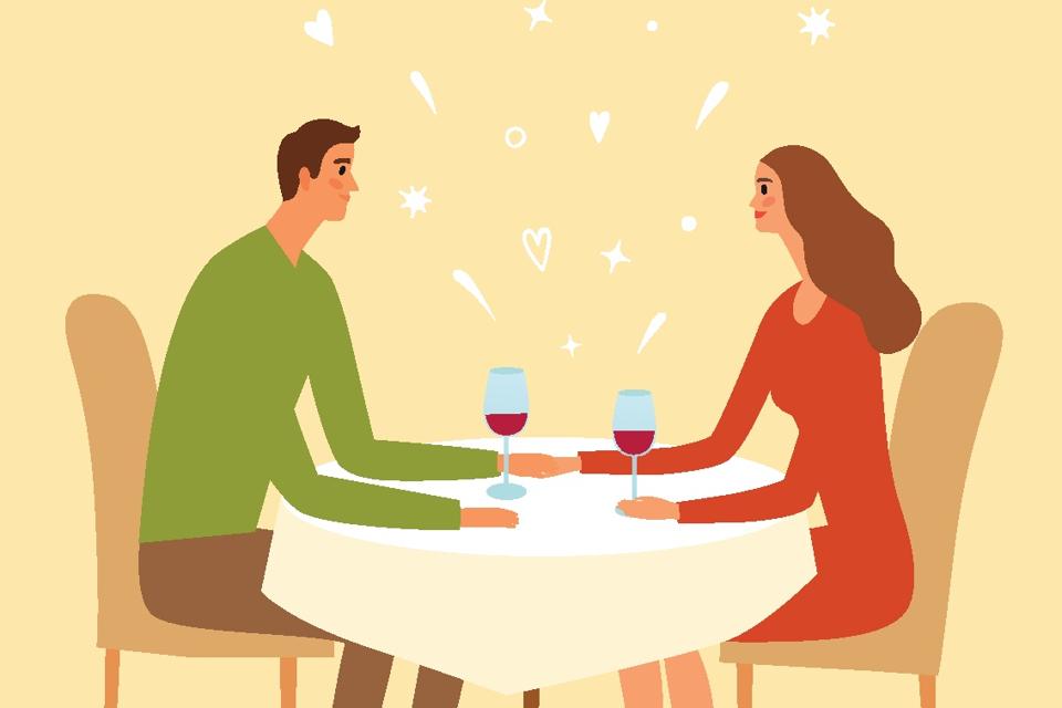 Pair sitting in a restaurant and holding hands.