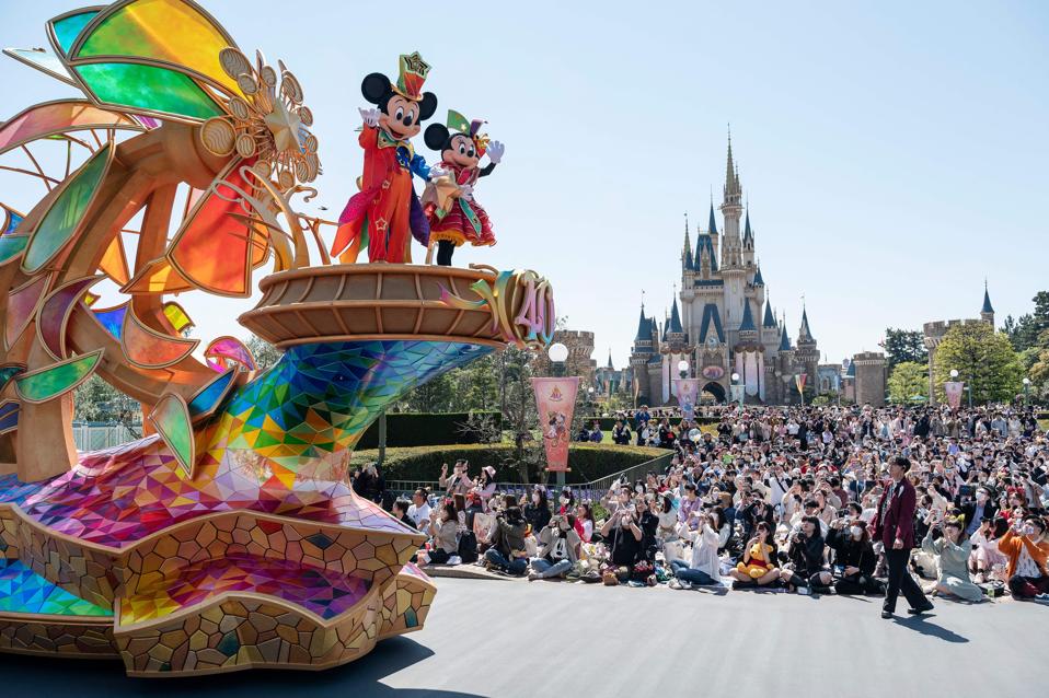 Disney characters Mickey and Minnie Mouse (top L) wave during a new daytime parade to mark the 40th anniversary of Tokyo Disneyland