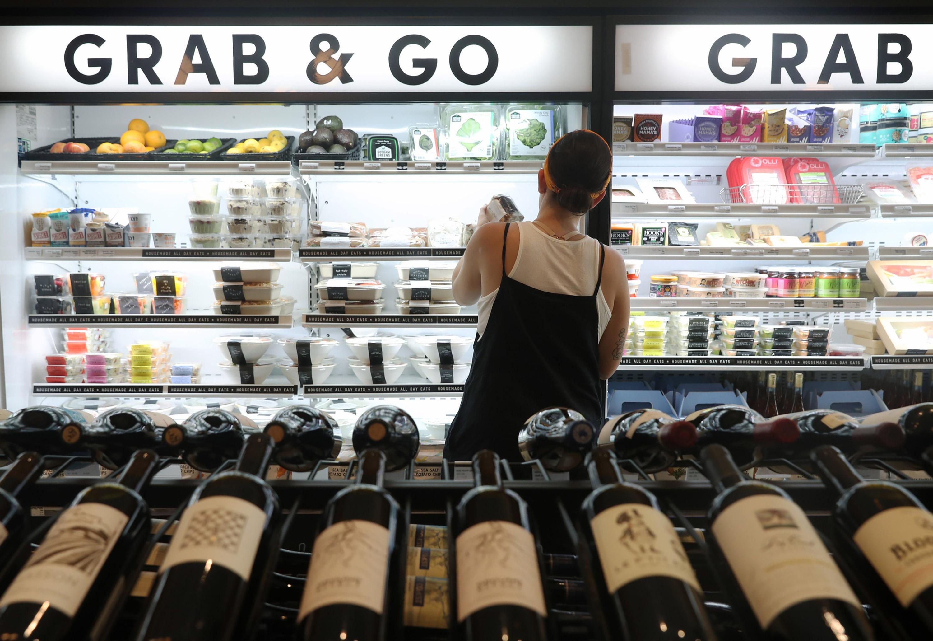 A shopper looks through the Grab & Go section at a Foxtrot grocery store in Chicago.