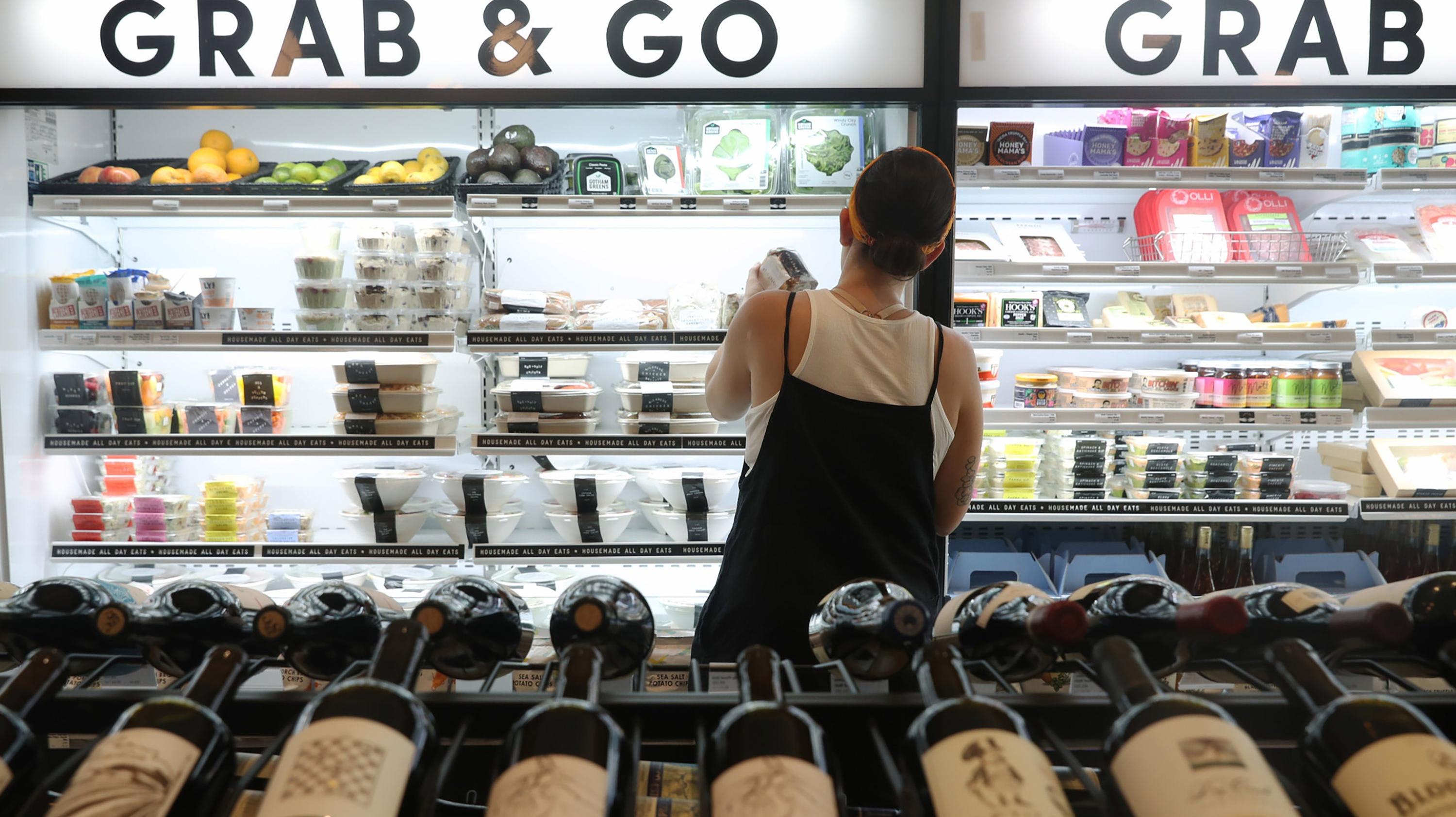 A shopper looks through the Grab & Go section at a Foxtrot grocery store in Chicago.