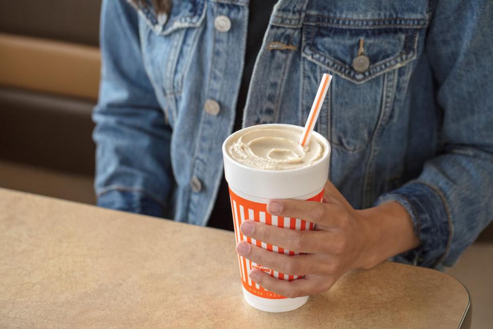 a person holding a cup with a frozen shake