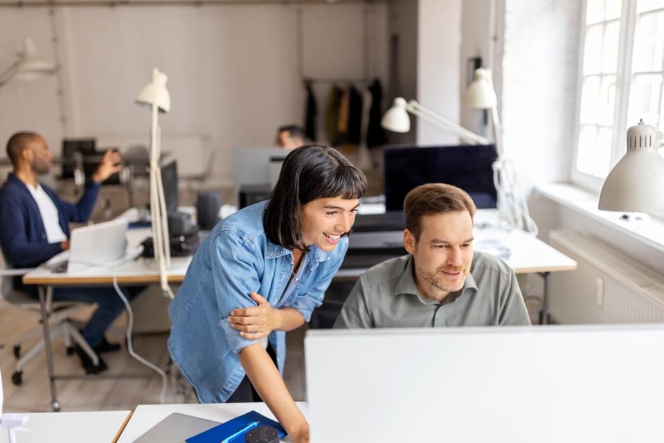 Two programmers working cooperating at IT company developing apps