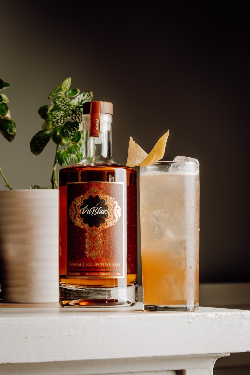 Whisky bottle and a cocktail in tall glass