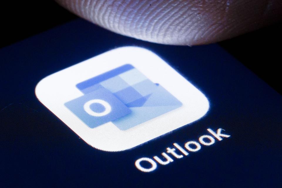 Microsoft Outlook app icon with finger hovering above.