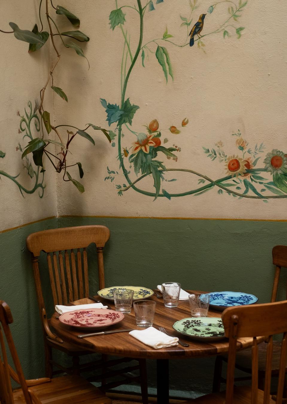a restaurant table in a corner with murals