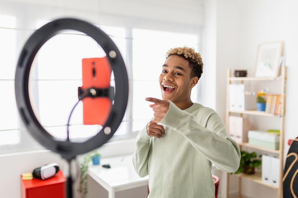 Young male creator recording online media video on his room