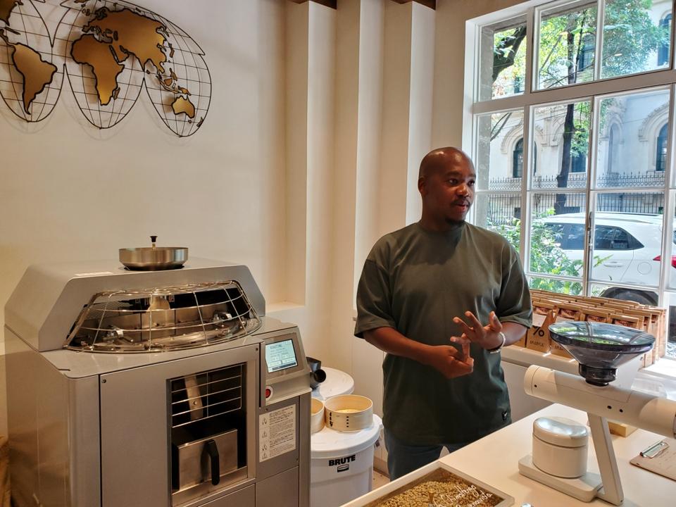 a man in front of a coffee roasting machine