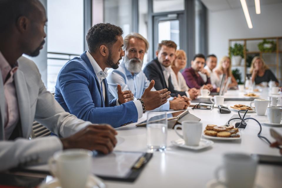 Diverse group of business colleagues having serious discussion at work
