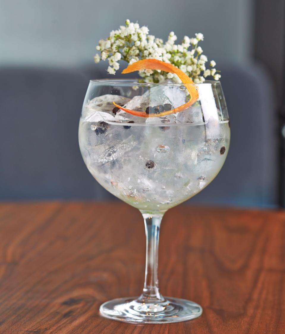 a clear cocktail in a wine glass
