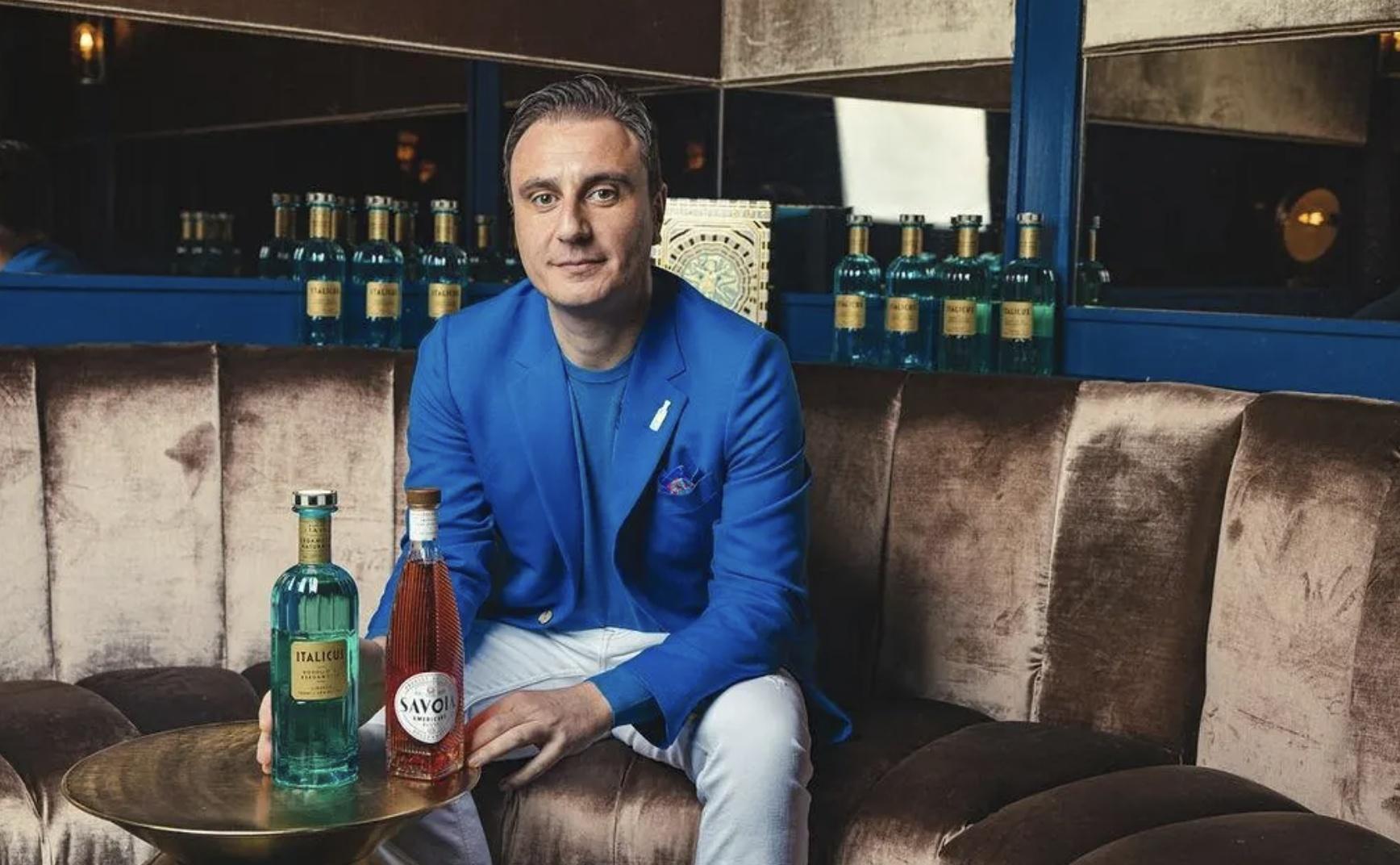 Giuseppe Gallo sits in front of bottles of his ItalSpirits products.