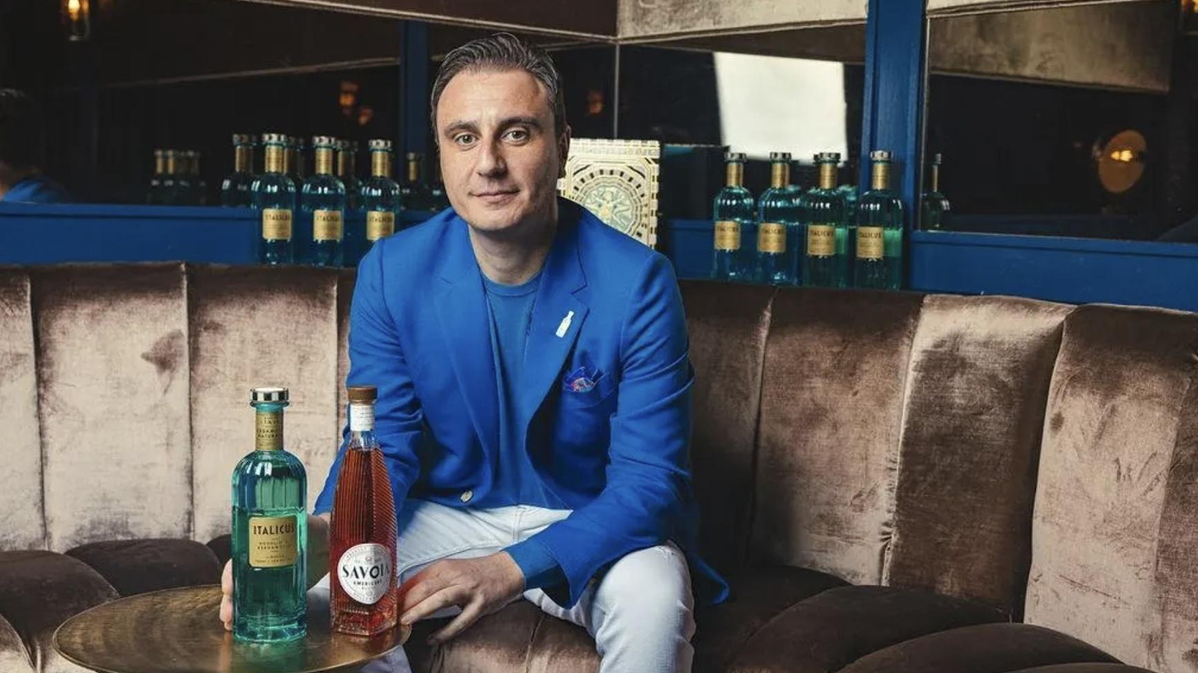 Giuseppe Gallo sits in front of bottles of his ItalSpirits products.