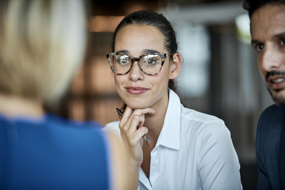 Confident businesswoman looking at colleague