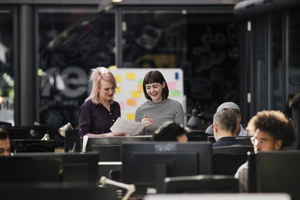 Office Manager Looking At Paperwork With Employee
