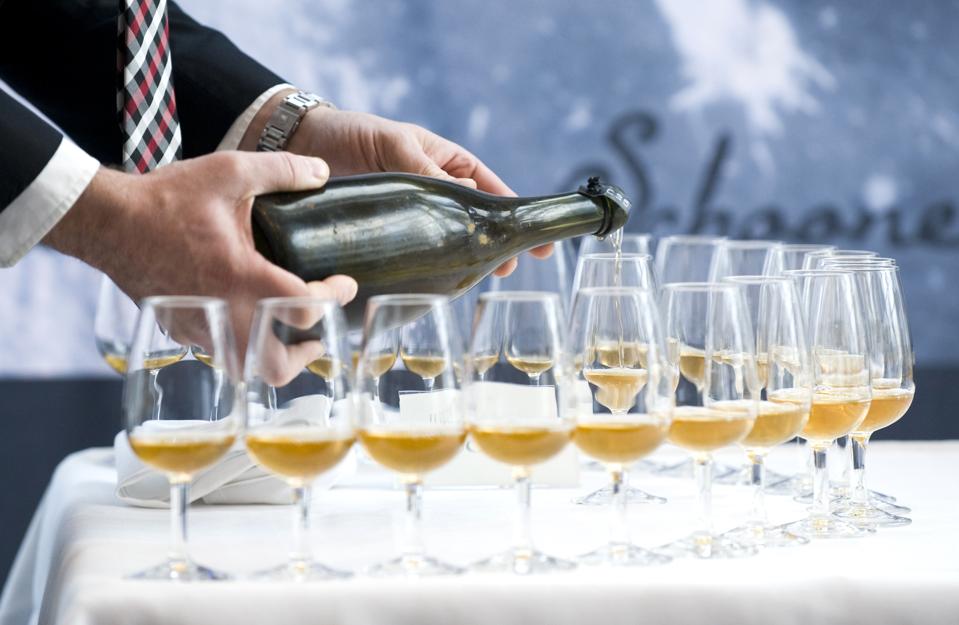 champagne poured into glasses by man in suit