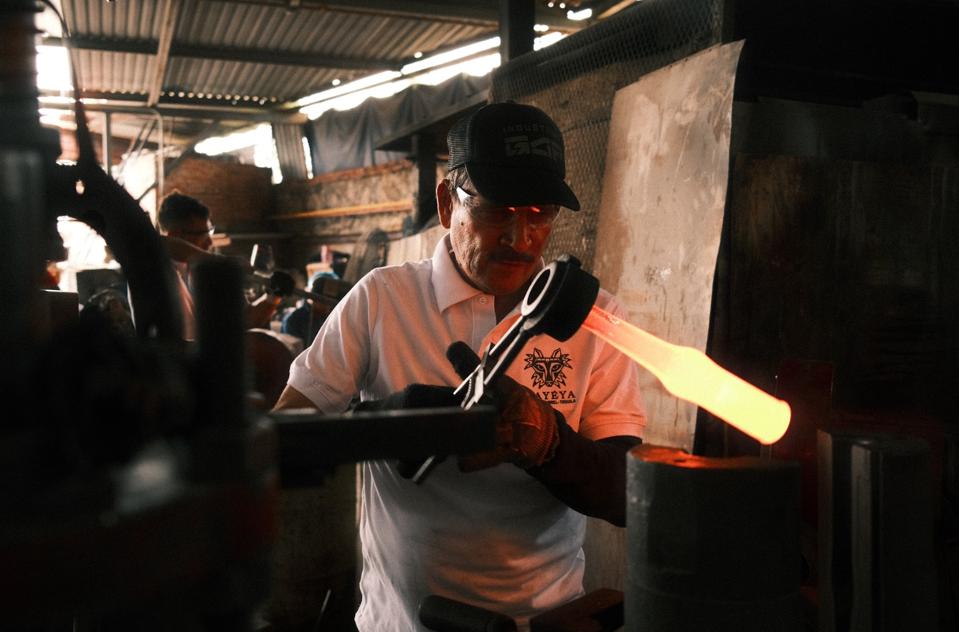 Recycled Mexican Coke bottles are melted into molten glass