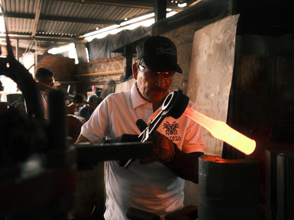 Recycled Mexican Coke bottles are melted into molten glass