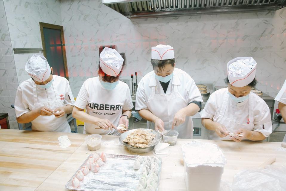 Cooks prepare dumplings in Nan Xiang Xiao Long Bao's kitchen